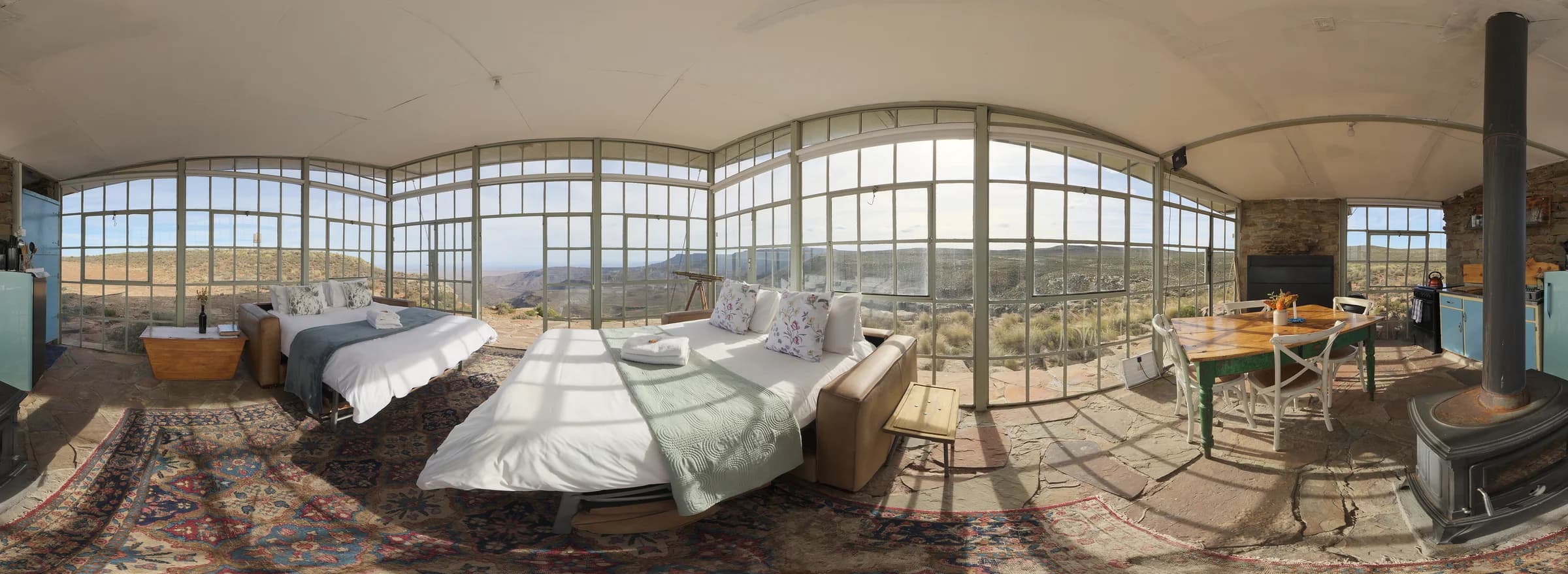 Photographic Glasshouse interior with living space and a view across the landscape